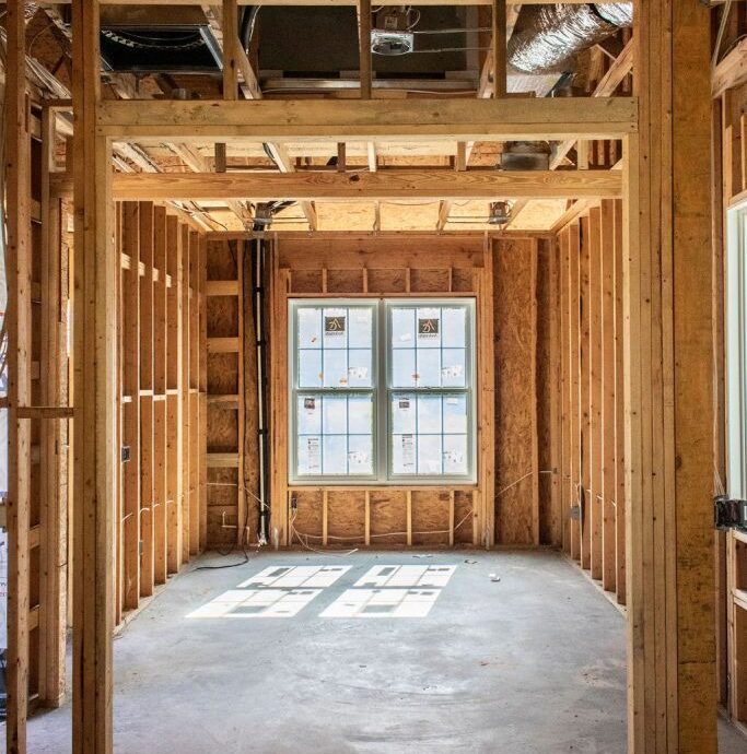 New home construction, wood framing, installed windows, concrete floor.