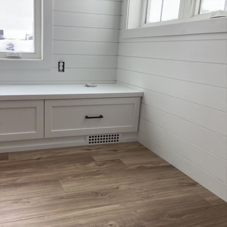 Built-in window seat with drawer, shiplap walls, wood floor
